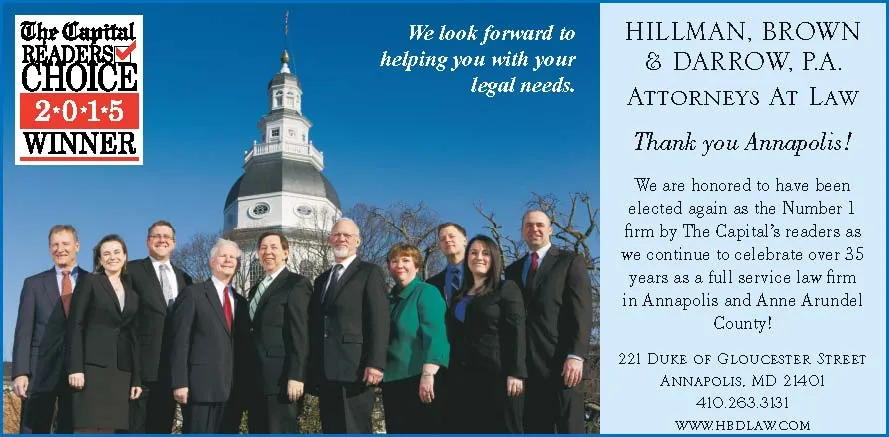 Group of nine professionally dressed attorneys standing outdoors with Maryland State House dome in background, blue sky, and text about Hillman, Brown & Darrow law firm.