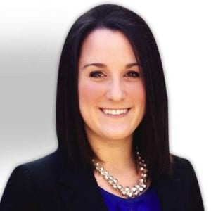 Professional headshot of a smiling woman with straight black hair, wearing a black blazer and pearl necklace.