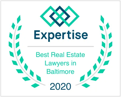 Award emblem with green laurel wreath, blue and green interlocking shapes, and text stating "Expertise Best Real Estate Lawyers in Baltimore 2020.