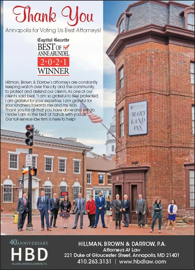 Group of formally dressed attorneys standing outside historic red brick Maryland Inn building in Annapolis.